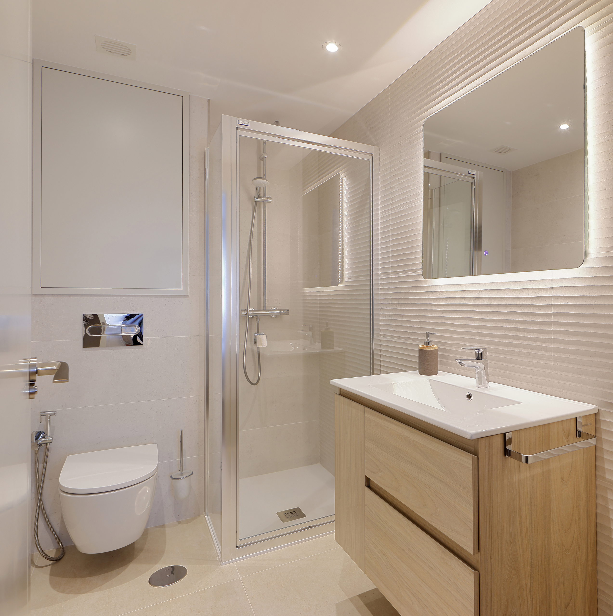 Baño con mueble de baño de madera con cajoneras y puertas sobre de mármol y  espejo con apliques de pared