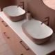 Dos lavabos Bicolor en color K-Coral sobre encimera K-Blanca, diseño moderno y elegante para baños contemporáneos.